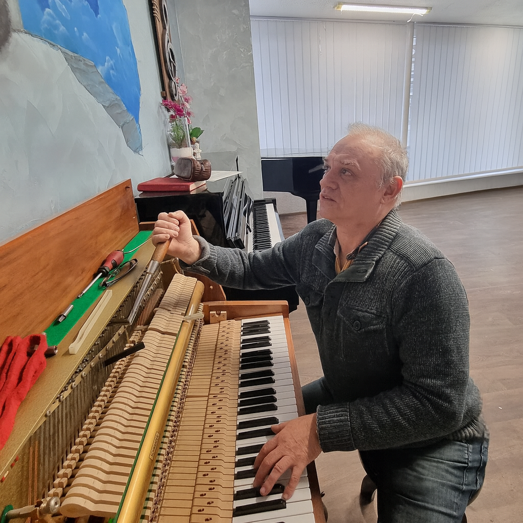 Alexander stimmt ein Klavier